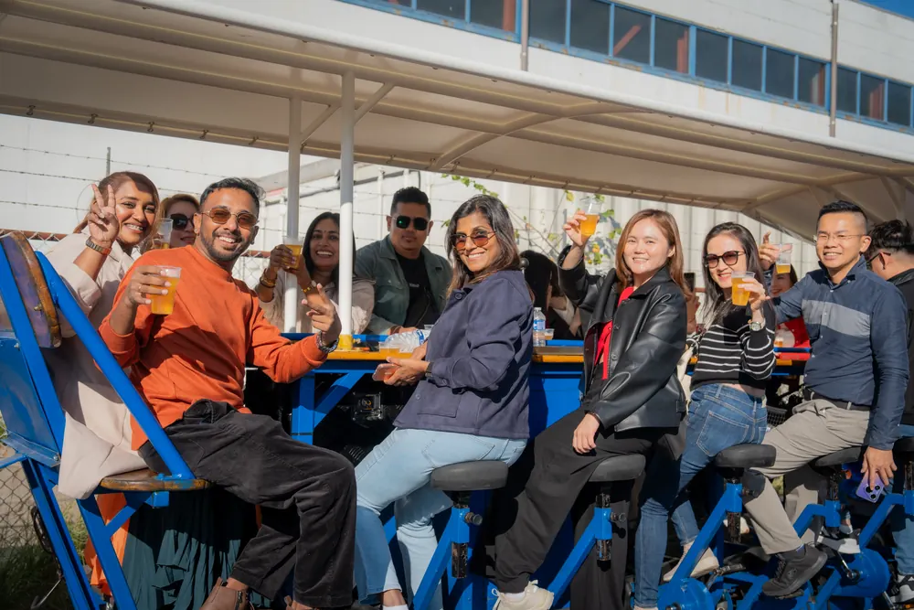 Group raising their beers on a DamTours beer bike in Amsterdam