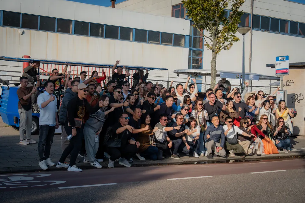 Large corporate group posing in front of the DamTours beer bikes