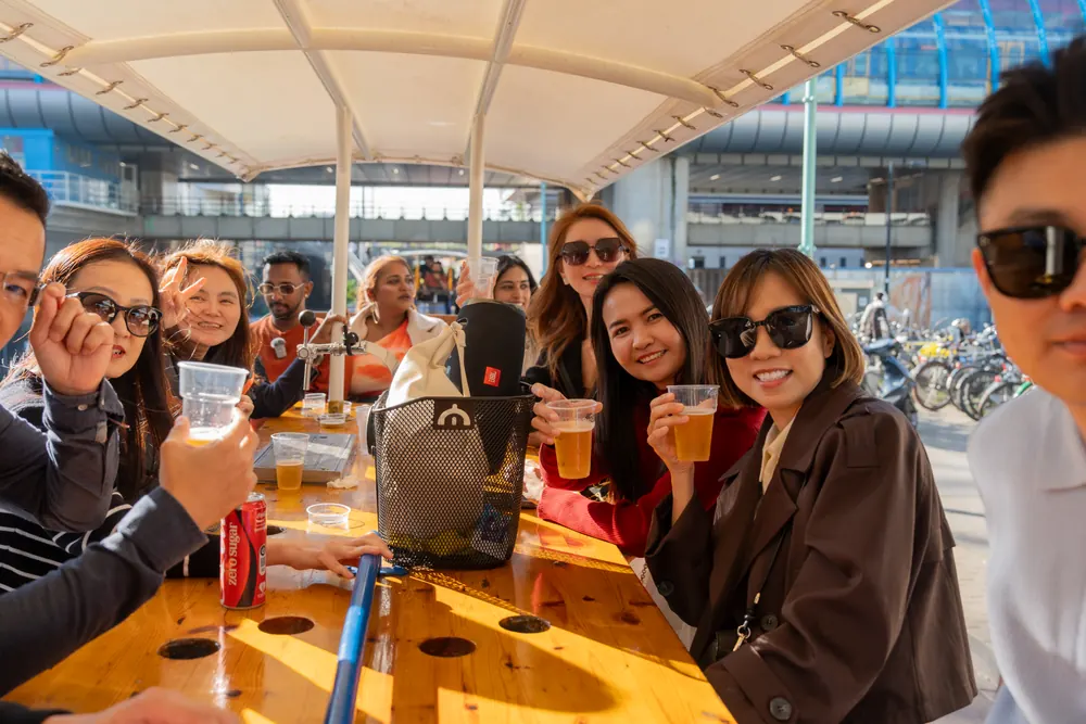 Friends toasting with beer on the beer bike