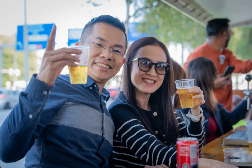 Two guests cheering with a cold beer on tour